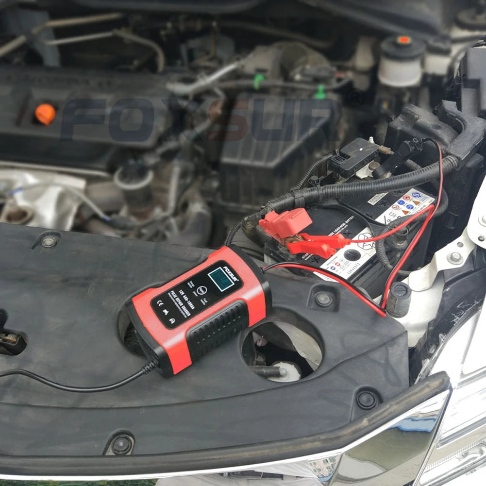 Battery charger connected to a car battery in the engine bay
