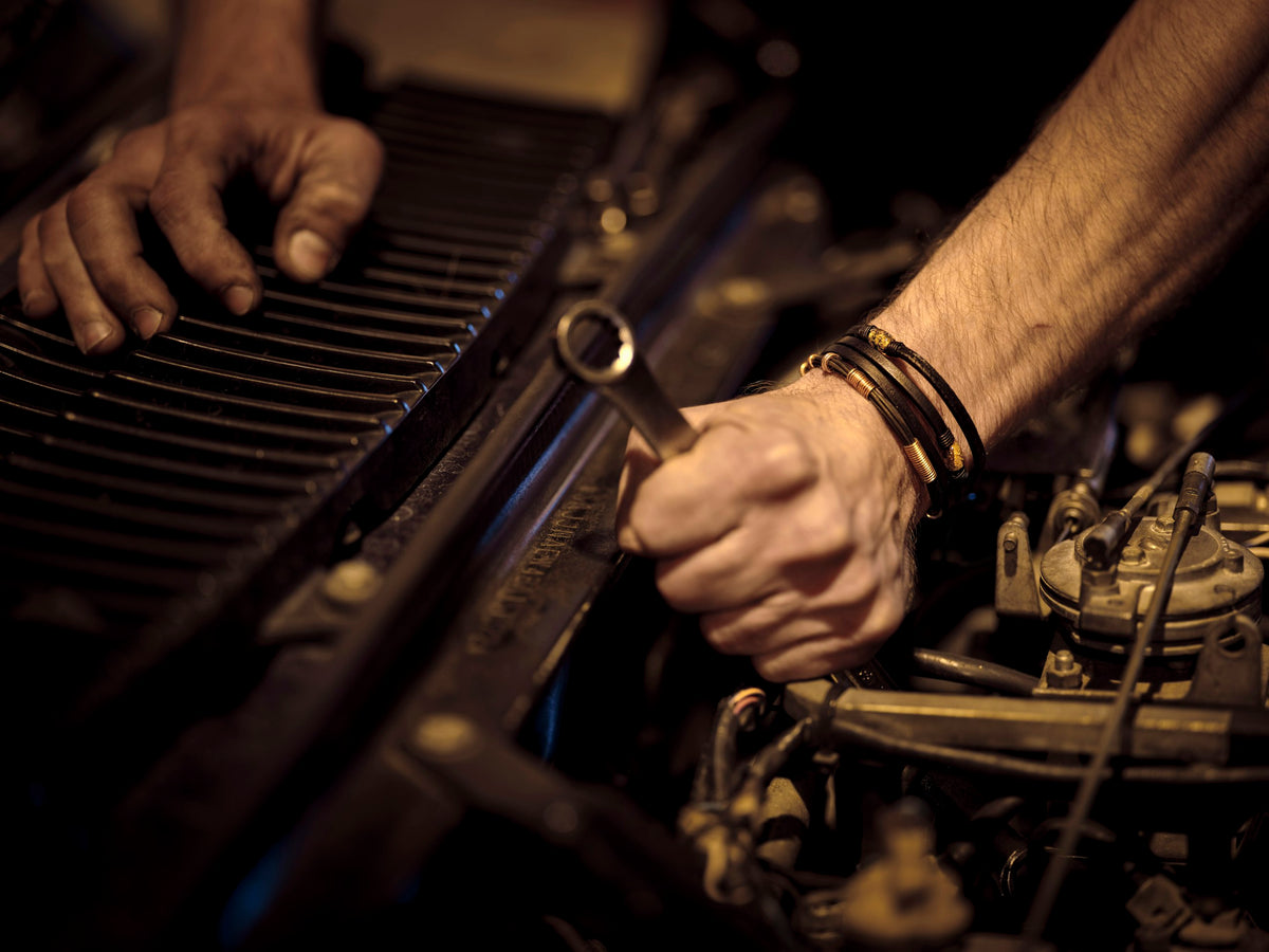 GarageBit hero - hands working on a car engine with a wrench